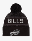 New Era Buffalo Bills Salute to Service black and charcoal gray cuffed knit hat featuring white BILLS lettering, monochromatic charging buffalo logo, camouflage-inspired pattern, and black pom.