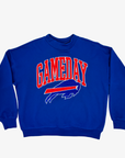 Women's Buffalo Bills royal blue crewneck sweatshirt with oversized red GAMEDAY lettering, charging buffalo logo, dropped shoulders, and ribbed cuffs.