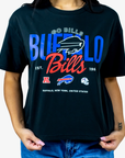 A person wearing a black Buffalo Bills graphic t-shirt with blue and red lettering, paired with blue jeans, against a plain white background.