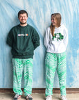 man and women wearing green and white zubaz pants and also irish crewnecks and sweatshirts