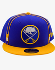New Era Buffalo Sabres royal blue and gold 9FIFTY snapback hat featuring an embroidered crossed-swords logo, gold crown piping, and contrasting gold flat visor.