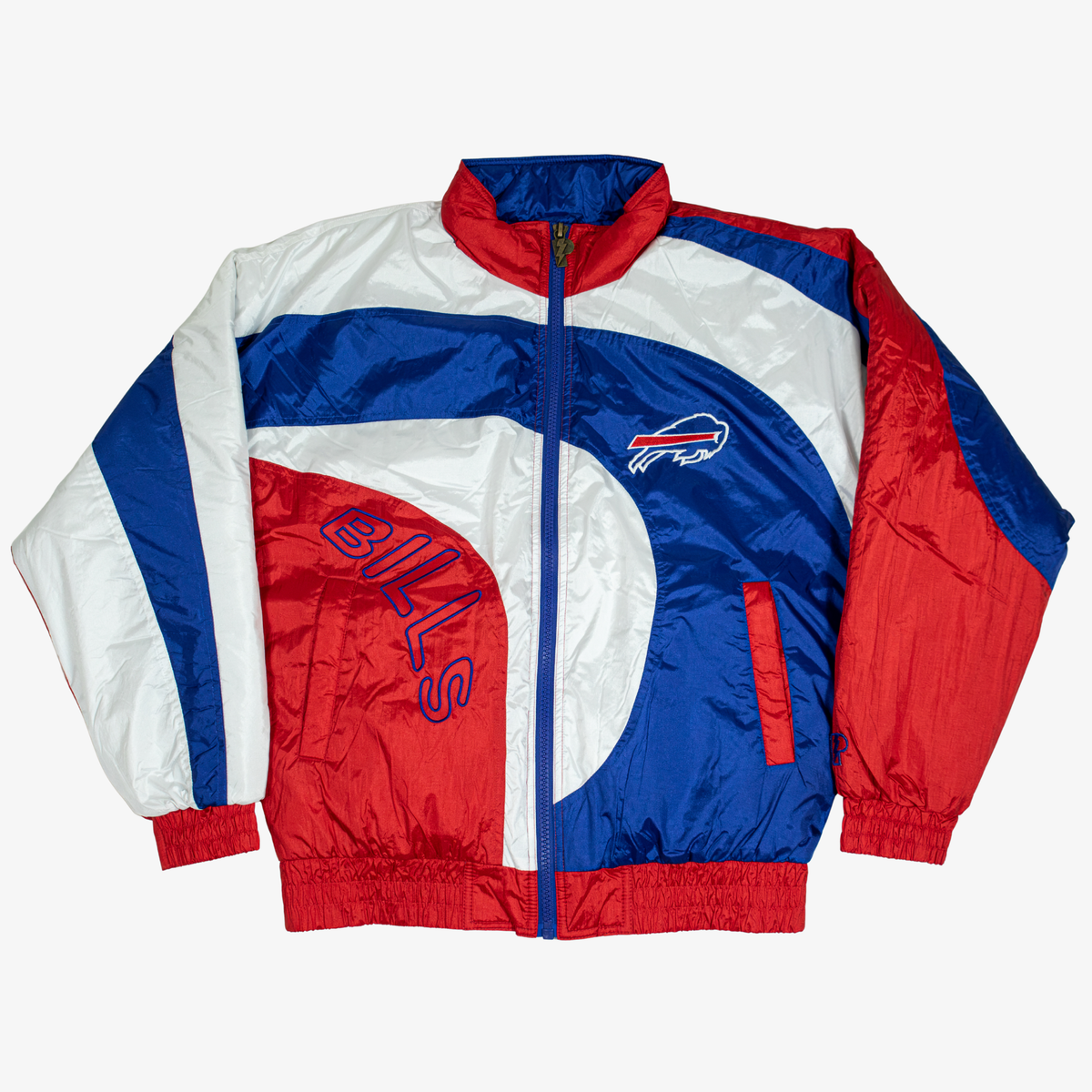 Pro Player Buffalo Bills retro windbreaker jacket featuring royal blue, red, and white curved colorblock panels, embroidered charging buffalo logo, outlined BILLS lettering, and full-zip front.