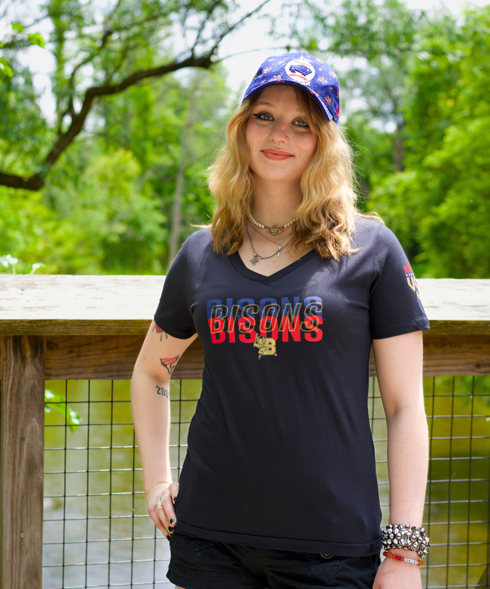 woman wearing a black buffalo bison shirt and floral blue bisons hat