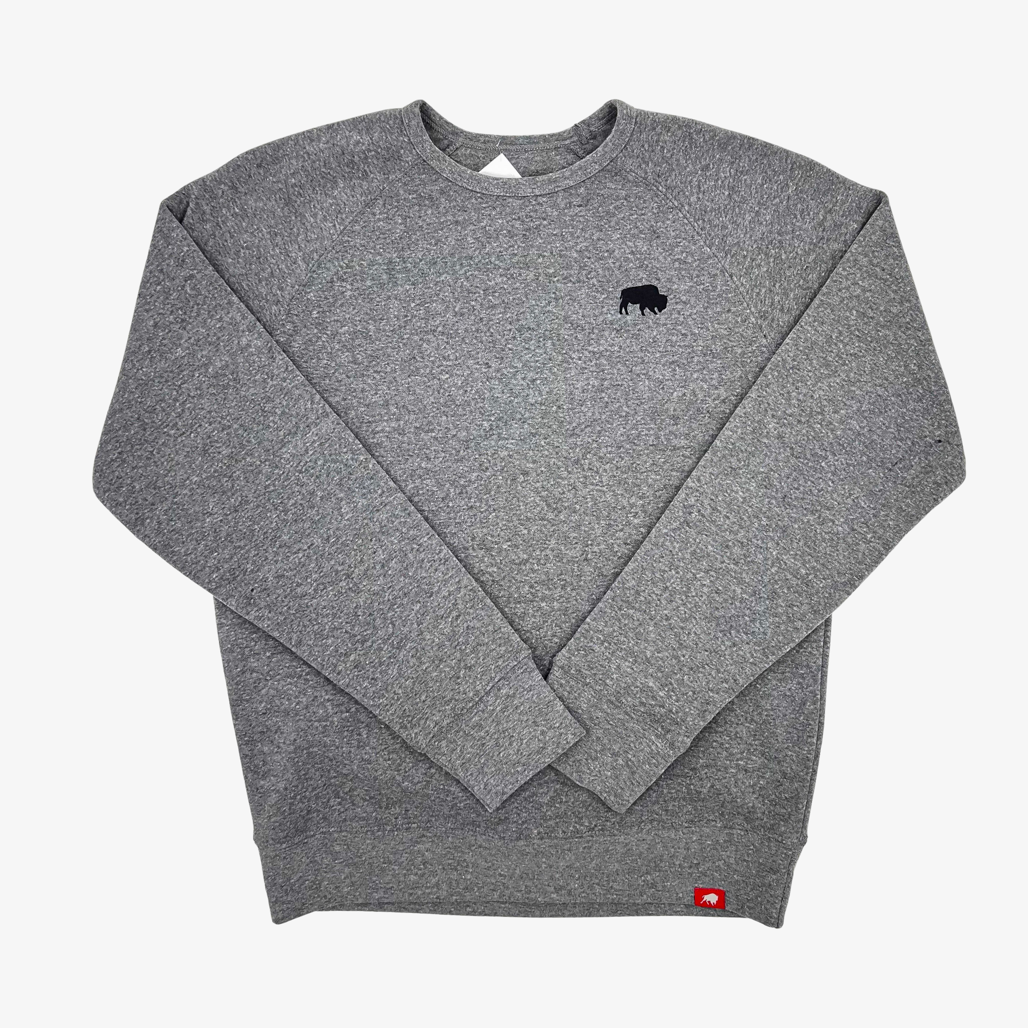 A heather gray crewneck sweatshirt with a small black bison logo on the left chest and a small red tag near the bottom hem, shown flat on a light gray background.