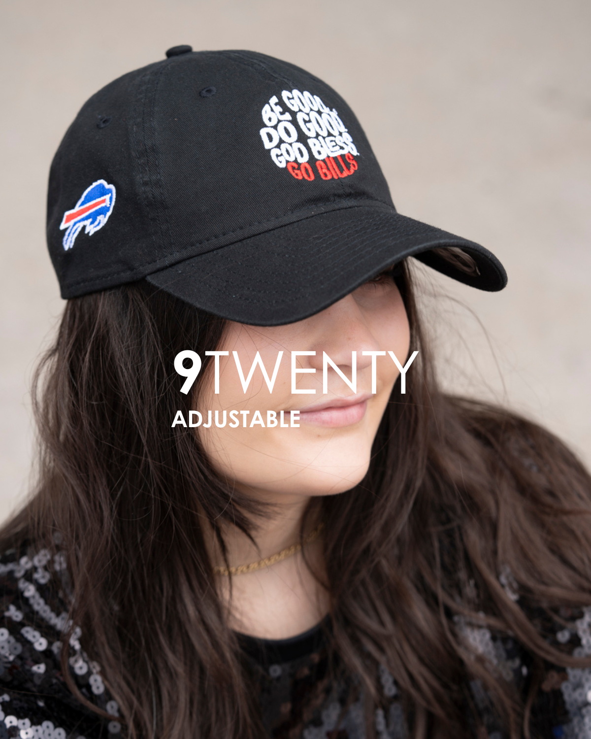 Black cap with text and logo, worn by a person, on a neutral background that is titled 9twenty adjustable.