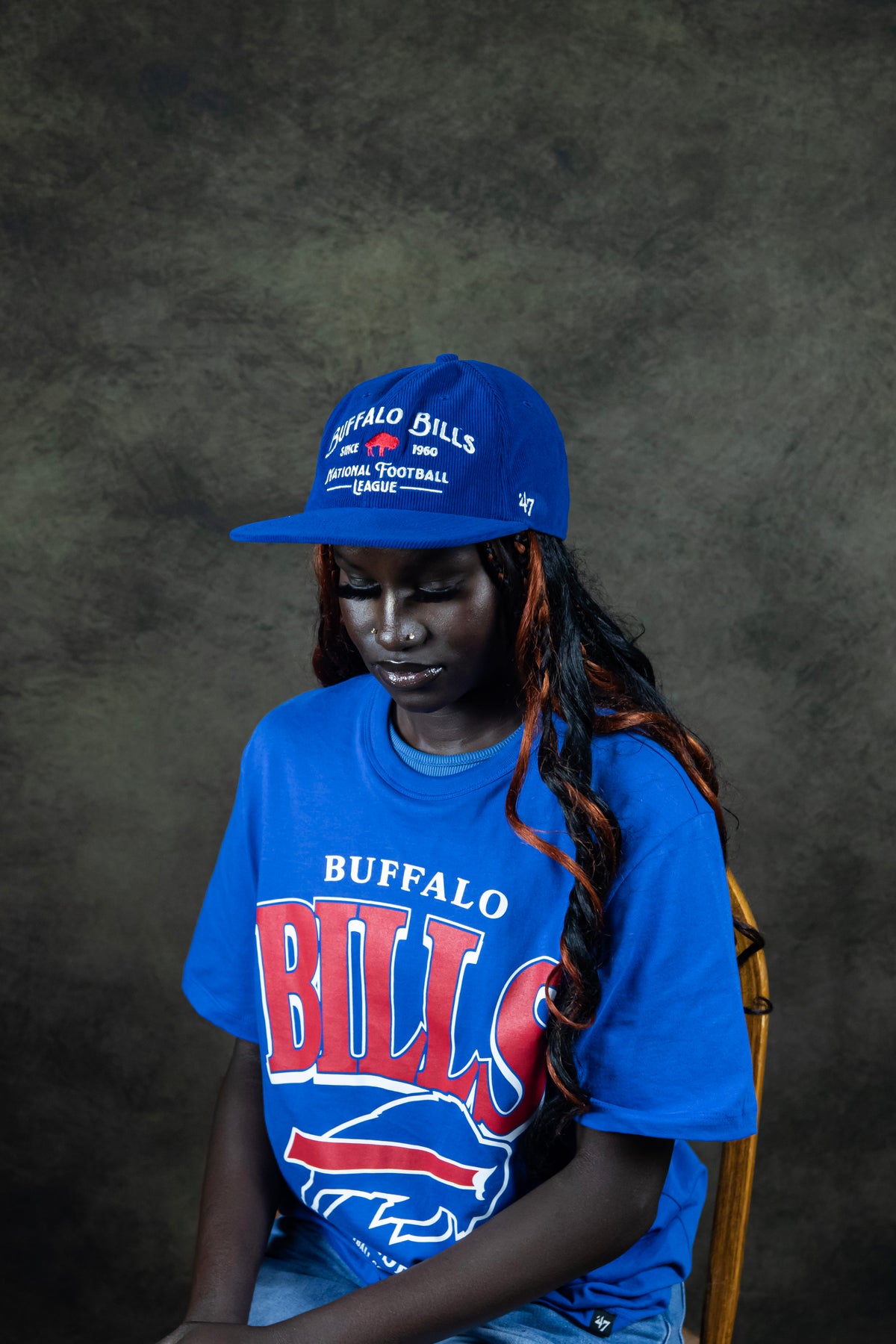 Women posing in a royal blue corduroy Buffalo Bills hat, wearing a Blue Buffalo Bills t-shirt. 