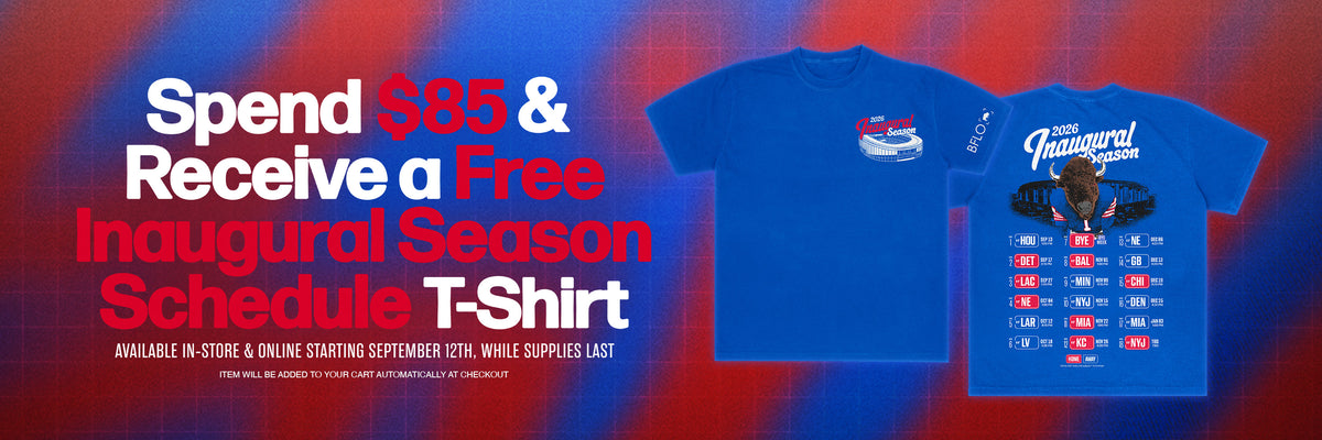 Blue graphic T-shirt displayed on a red-to-blue gradient background with promotional text reading 'Spend $85 & Receive a Free Inaugural Season Schedule T-Shirt.' The shirt features a white car graphic and a driver portrait with 'The Inaugural Season' text.