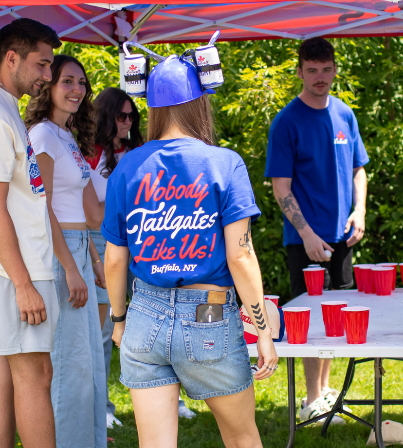 people playing pong and mainly showing girl from behind wearing the nobody tailgates like us royal tshirt