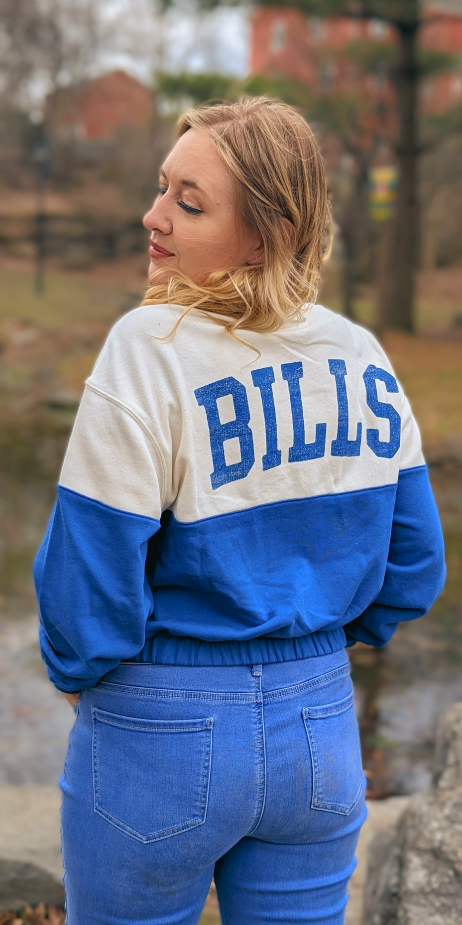 woman wearing a cream and blue buffalo bills cropped crewneck