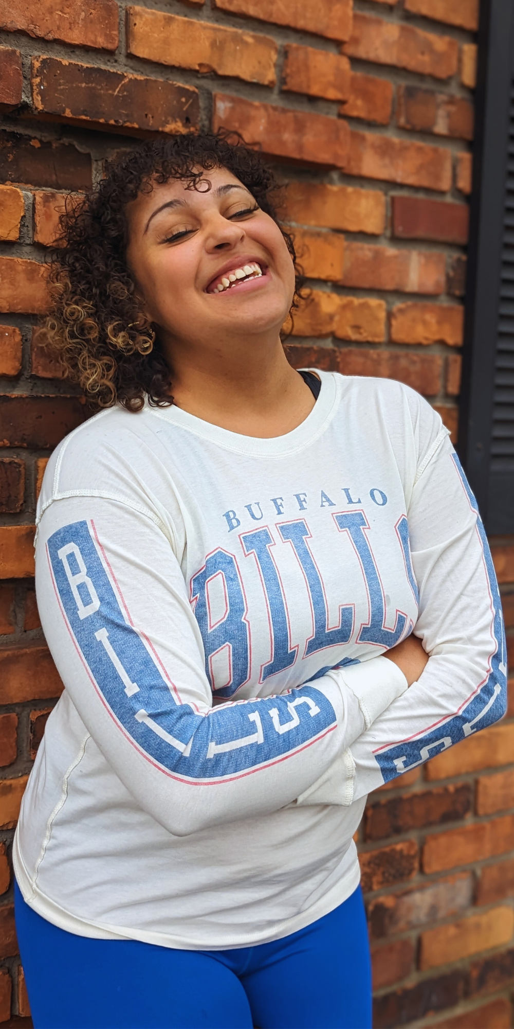woman smiling for a photo wearing wearing a vintage buffalo bills long sleeve shirt