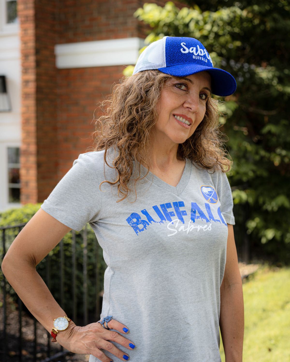 woman wearing buffalo sabers sparkle hat and gray sabres shirt. link buffalo sabres womens apparel.