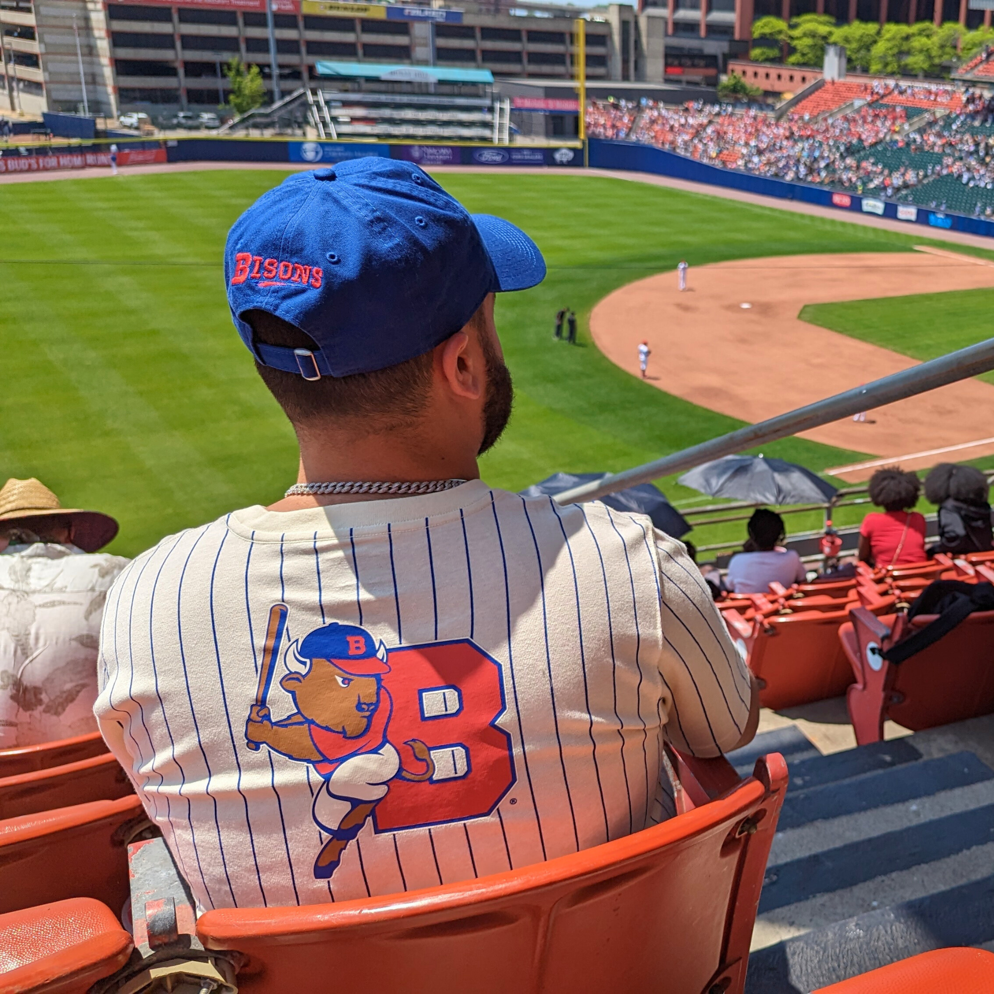 man sitting at buffalo bisons game in the stands looking out at the field