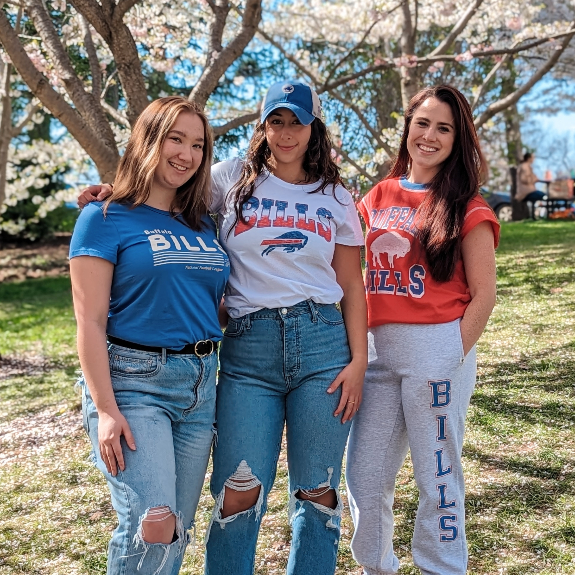 women posing for a picture in a park wearing buffalo bills apparel