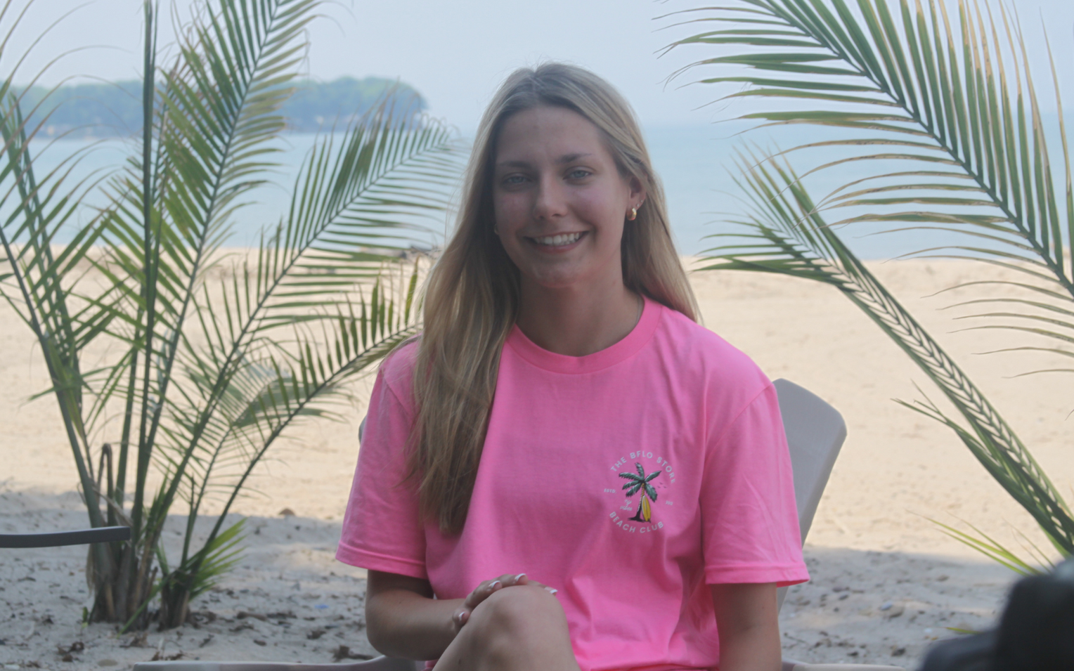 woman at the beach wearing a pink bflo beach club tshirt