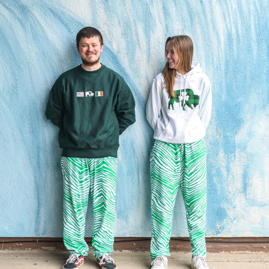 man and women wearing green and white zubaz pants and also irish crewnecks and sweatshirts